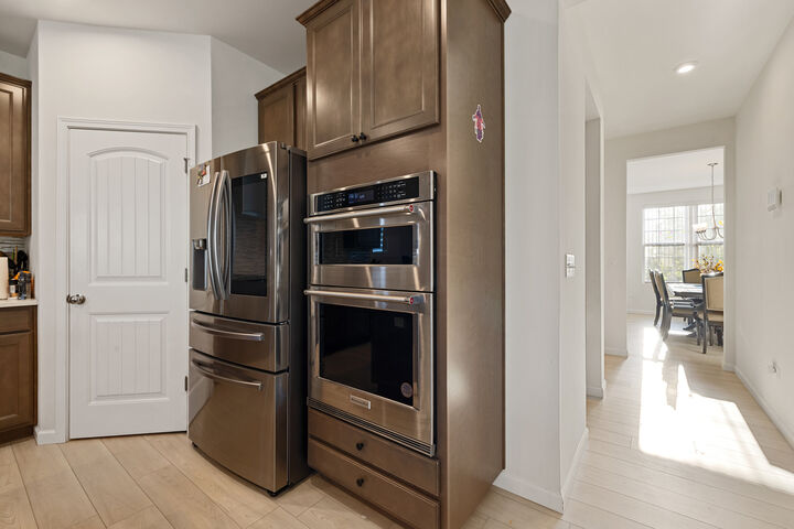 Wall oven and microwave, with the pantry door beside them.